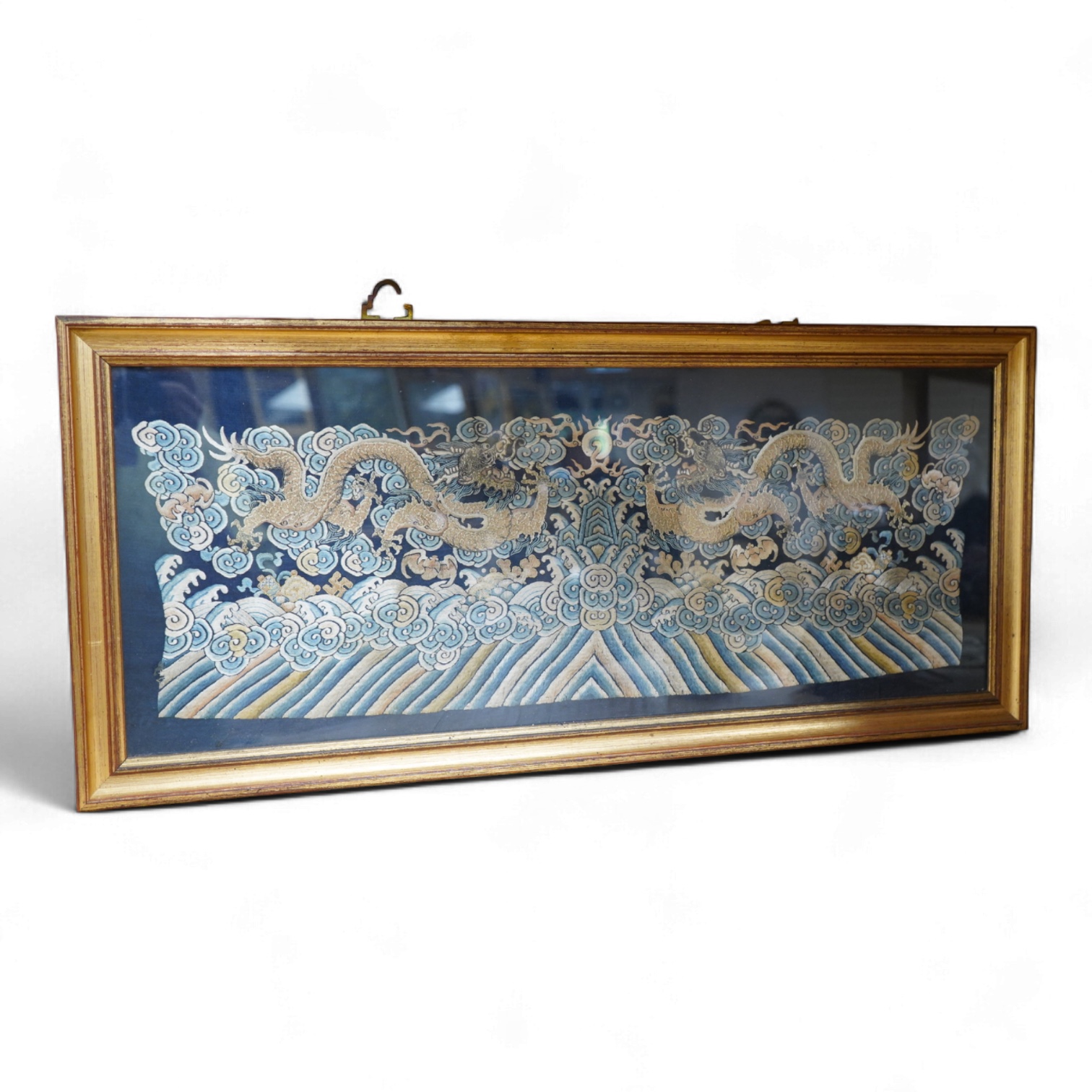 A framed late 19th / early 20th century Chinese silk embroidered five claw dragon panel from the base of a robe, 59cm wide x 23cm high. Condition - good, colours and embroidery strong